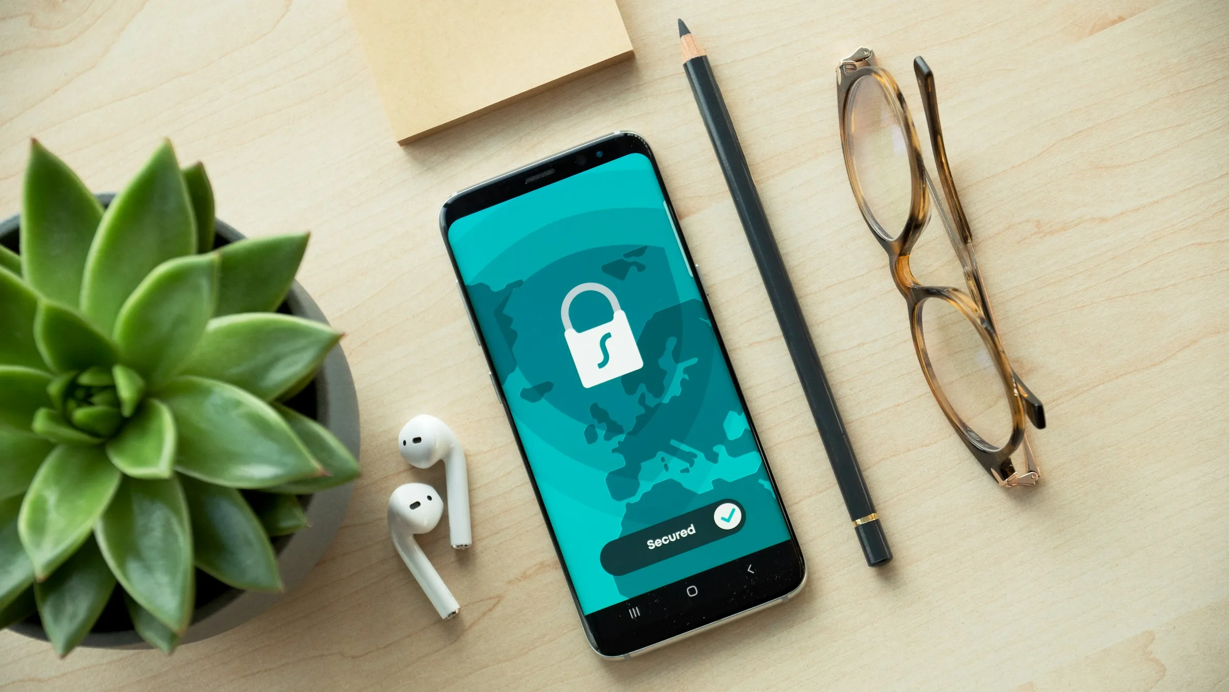 A smartphone on a desk showing a padlock and a “Secured” status